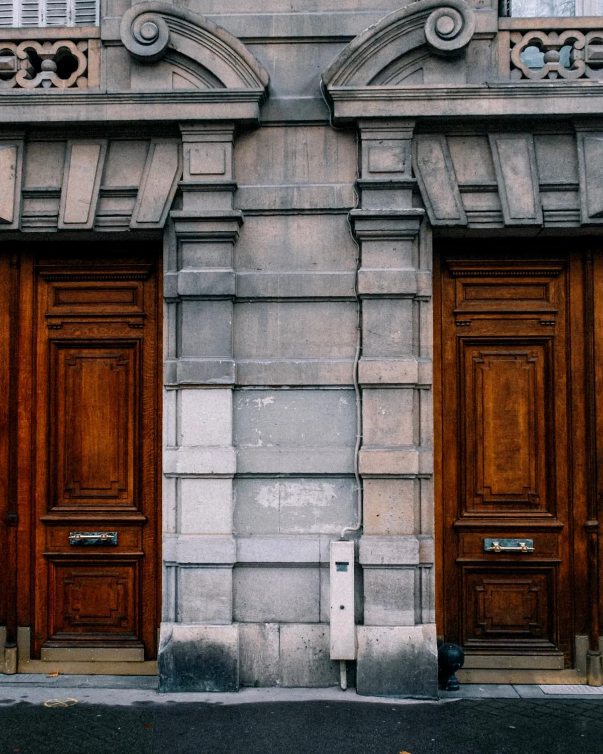 Deux hautes portes de bois sombre dans une façade de pierre