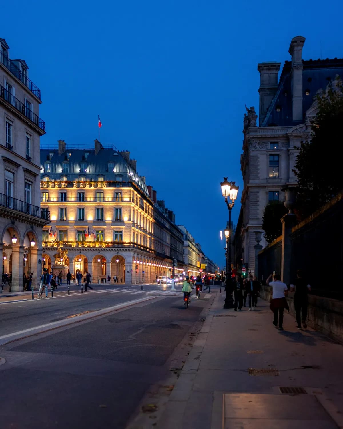 La rue de Rivoli à la nuit tombée, façades éclairées et lampadaires allumés